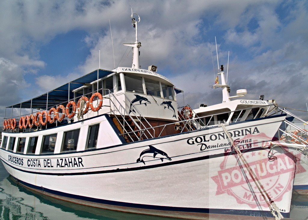 Golondrina tour boat cruising Costa del Azahar waters | Golondrina passenger ferry docked in a harbor, offering coastal cruises - Realized with Pictrs.com