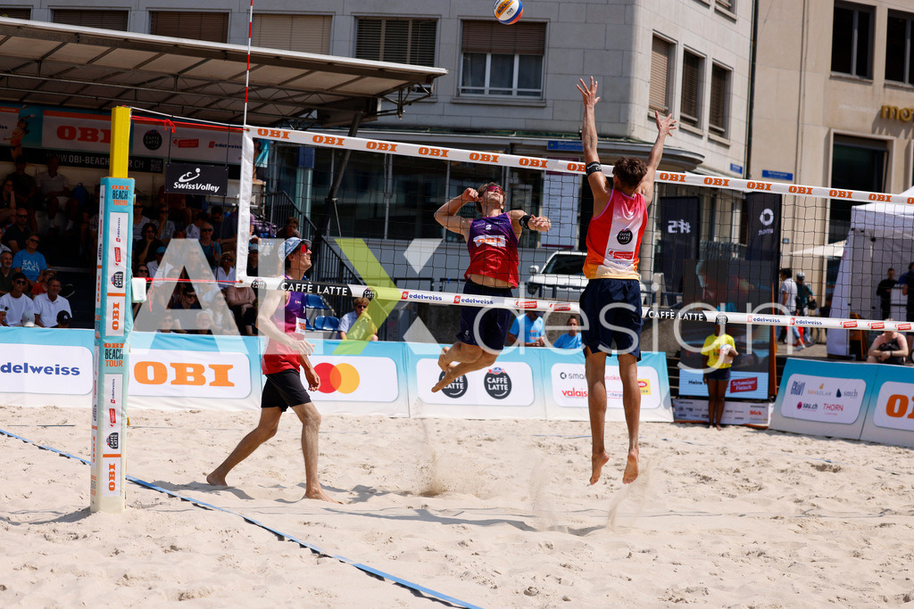 Obi BeachTour 2026 - Basel | BASEL, SWITZERLAND - JULY 19: YVES HAUSSENER (SUI) attack / spike against LUC EMANUEL FLÜCKIGER (SUI) block during the Obi BeachTour 2026 match between DILLIER / FLÜCKIGER (SUI) and HAGENBUCH / HAUSSENER (SUI) at Barfüsserplatz on July 19, 2026 in Basel, Switzerland. - Realisiert mit Pictrs.com