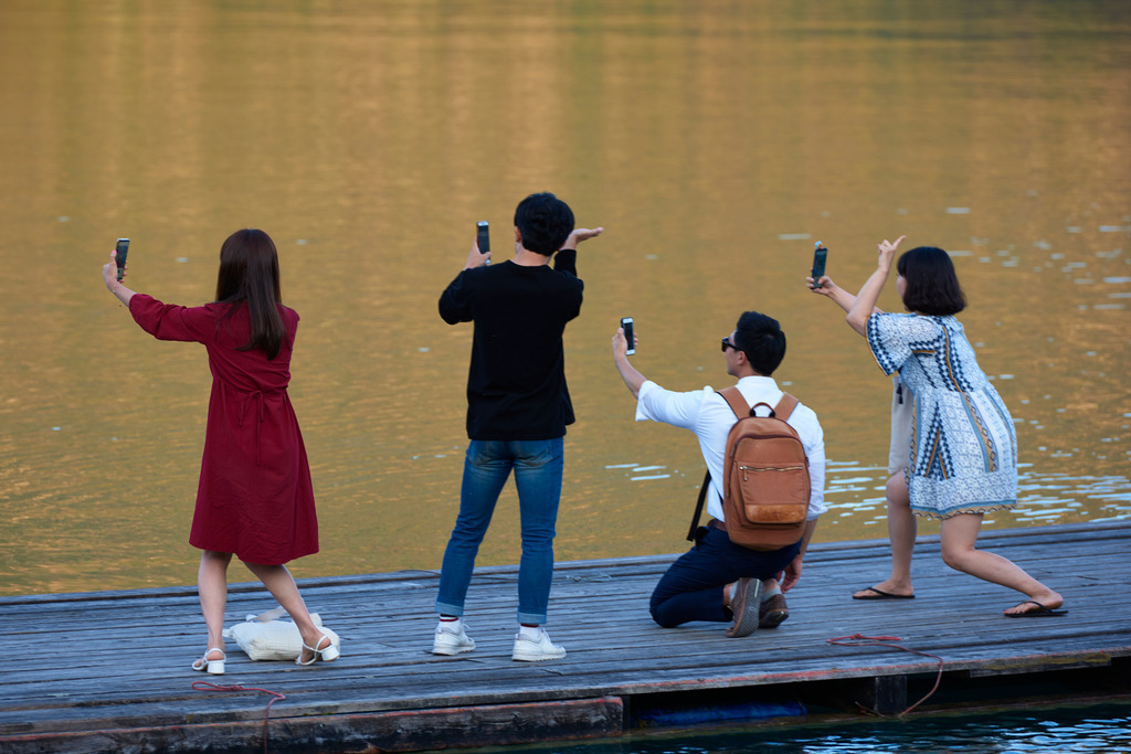 Vier JapanischeTouristen machen Selfies | St. Gilgen, Austria - September 19, 2018: Vier JapanischeTouristen machen Selfies am Wolfgangsee. - Realisiert mit Pictrs.com