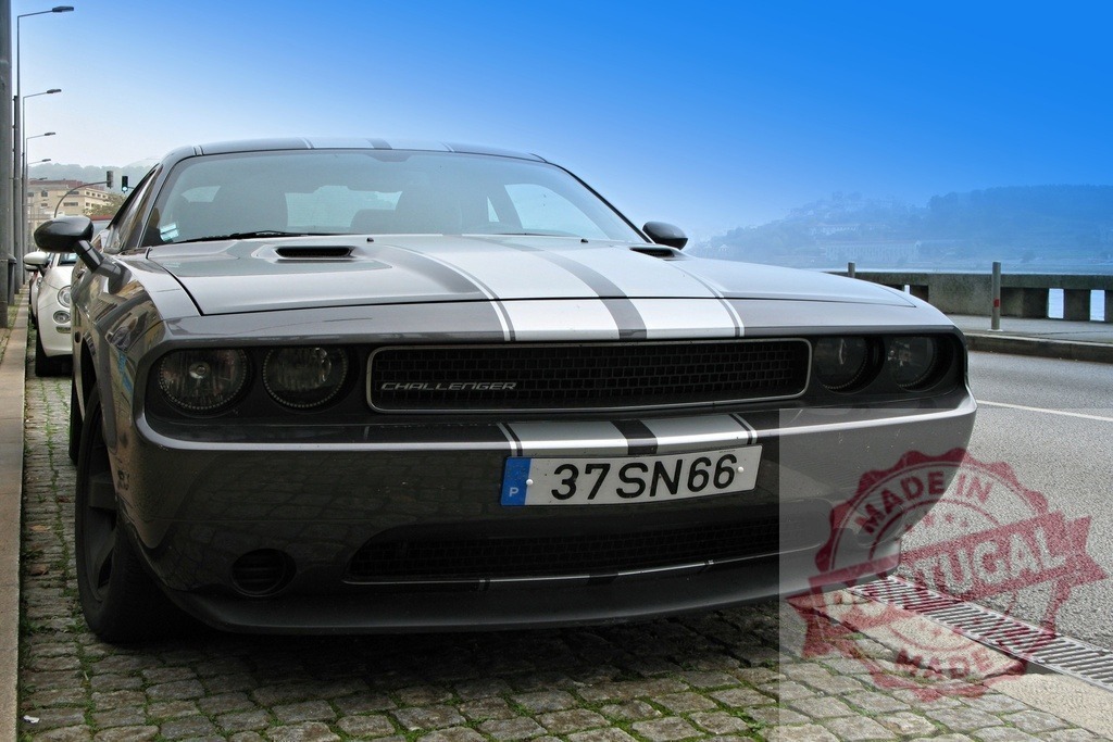Dodge Challenger muscle car on a cobblestone street | Gray Dodge Challenger muscle car with racing stripes parked on a public street - Realisiert mit Pictrs.com