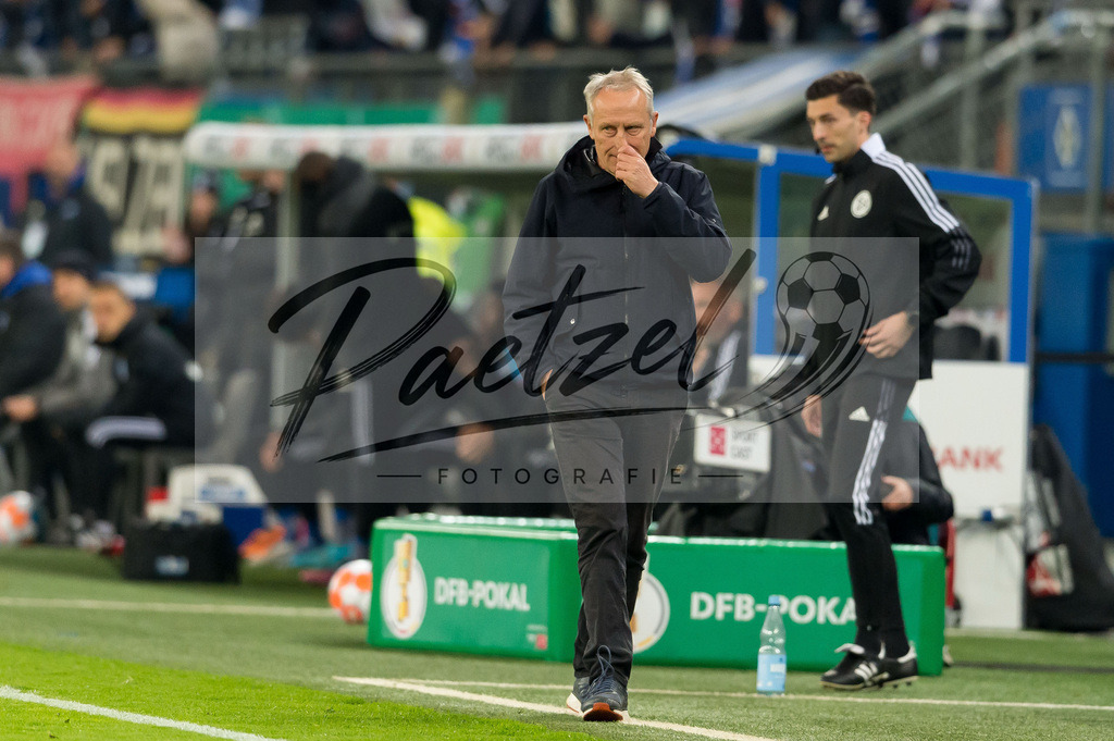 HSVSCF20220419_113 | Fussball, Herren: Trainer Christian Streich (SC Freiburg) schaut beim DFB-Pokal-Halbfinalspiel zwischen Hamburger SV und SC Freiburg im Volksparkstadion am 19.04.2022 in Hamburg, Deutschland.DFB / DFL REGULATIONS PROHIBIT ANY USE OF PHOTOGRAPHS AS IMAGE SEQUENCES AND/OR QUASI-VIDEO. - Realisiert mit Pictrs.com