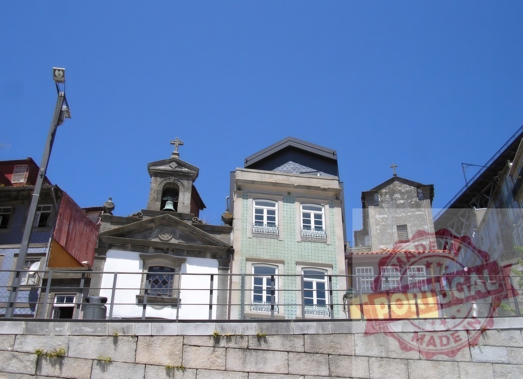 Porto cityscape with historic chapel and azulejo tiled building. Porto - Portugal | Colorful traditional buildings and a small church bell tower under a clear blue sky in Porto - Realized with Pictrs.com