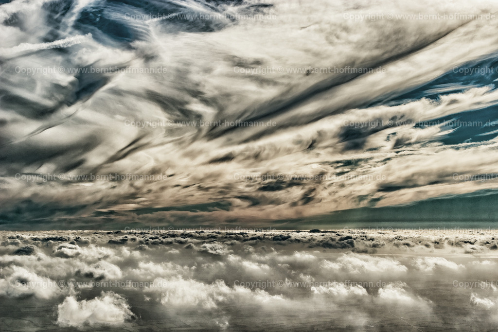 PLB_1453m_V2_Inversion_max90x60 | LUFTBILD. Flug über den Wolken – Inversionsschicht 02. __ Dunst und dünne Wolkendecke von oben betrachtet. Darüber ein wildes Himmelsbild mit Cirrus-Bewölkung. __ Anmutung = farbreduziert. - Realisiert mit Pictrs.com