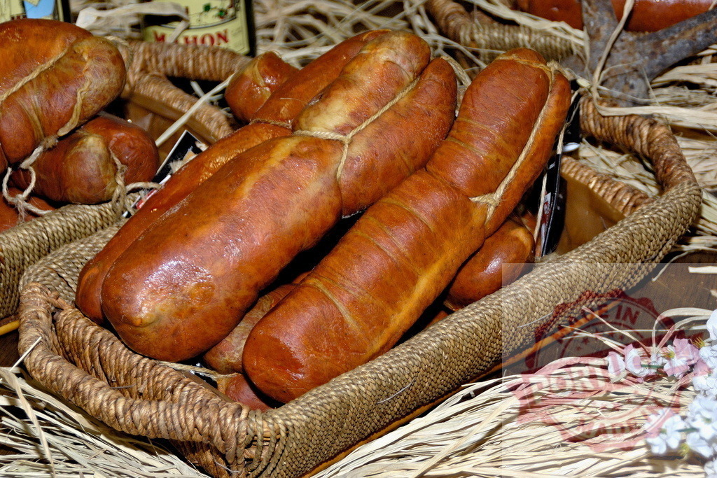 Sobrassada sausages in a basket on straw | Traditional Sobrassada sausages from the Balearic Islands in a rustic basket - Realisiert mit Pictrs.com