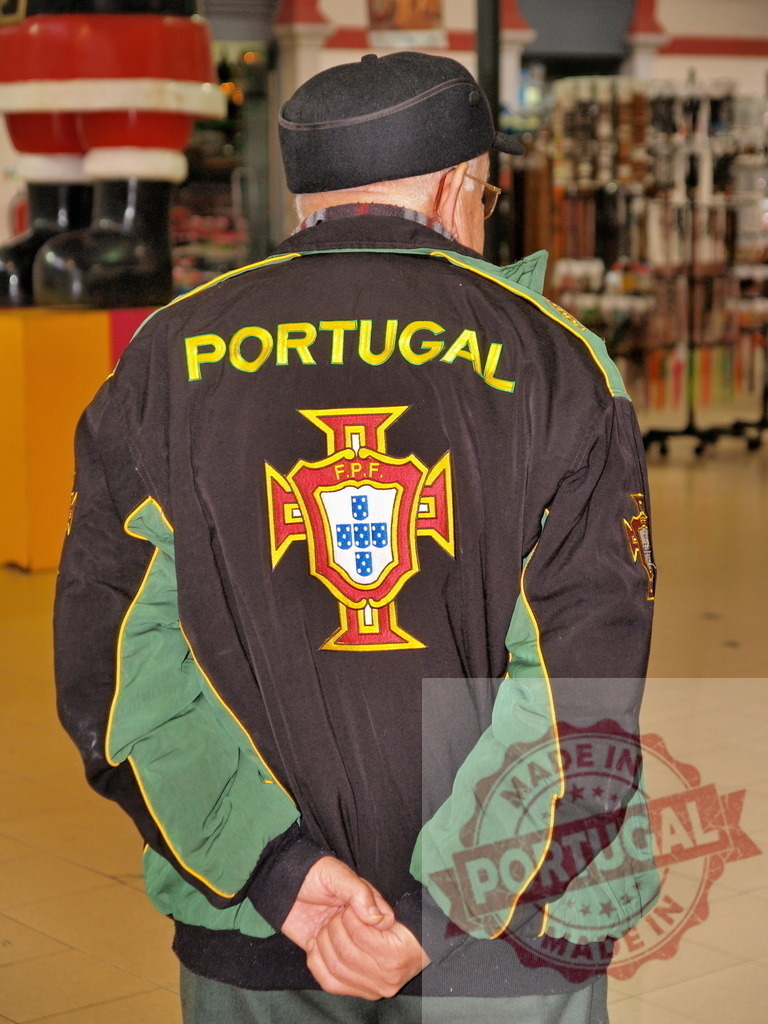 Elderly man wearing Portugal jacket standing in shopping mall | Senior man wearing Portugal sports jacket standing in a shopping center - Realisiert mit Pictrs.com