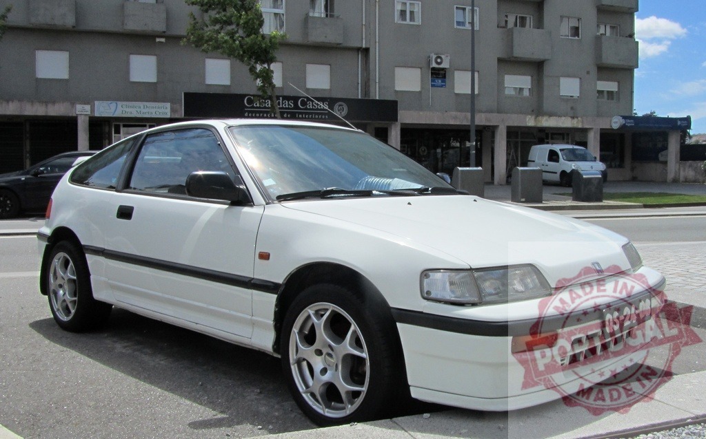 White Honda CRX parked on the street in Portugal | Classic white Honda CRX parked on a street in Portugal, showcasing its timeless design - Realized with Pictrs.com