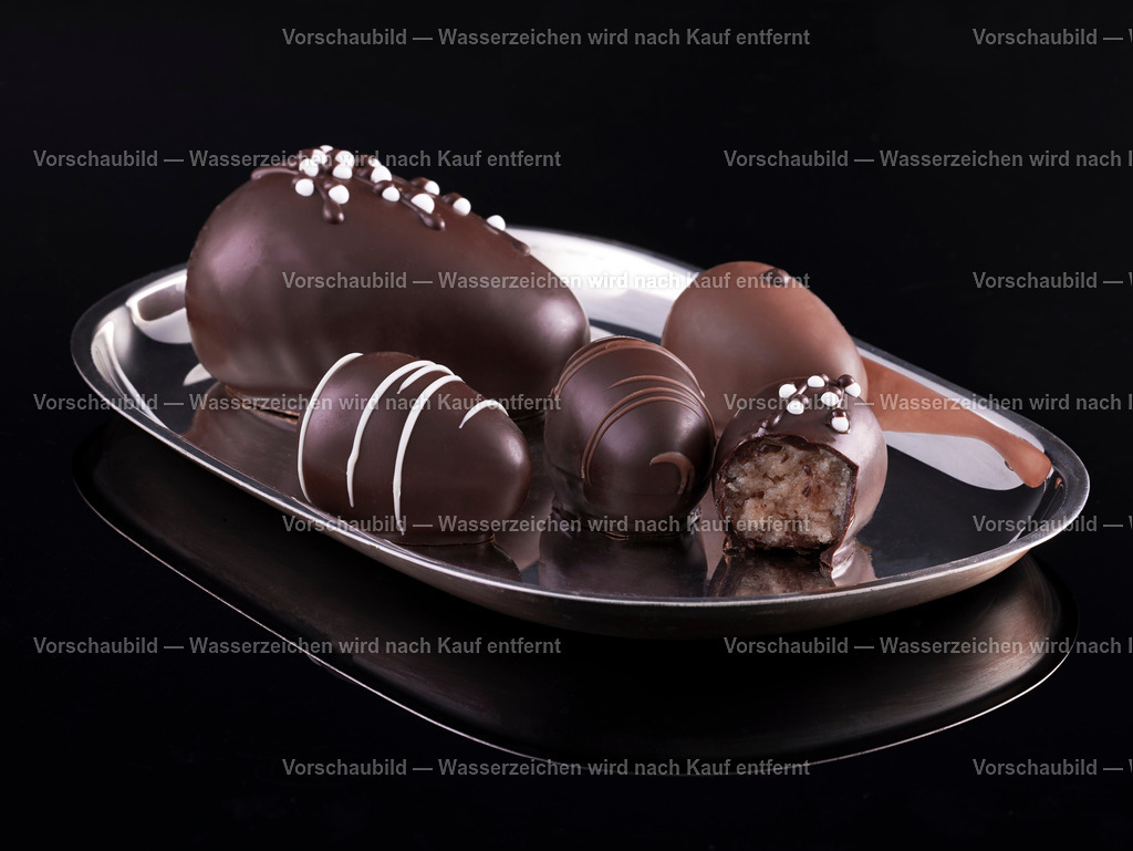 Silberne Servierplatte mit edlen, verzierten Marzipan Pralinen auf schwarzem Untergrund | Silberne Servierplatte mit edlen, verzierten Marzipan Pralinen auf schwarzem Untergrund mit Spiegelungen. - Realisiert mit Pictrs.com