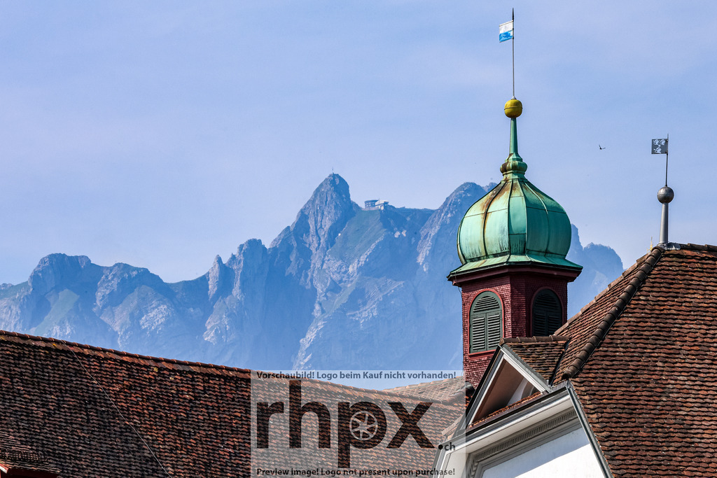 Luzerner Dächer mit Pilatus im Hintergrund | Dachziegel. Turm. Alpenglühen.Ein einzigartiger Blickwinkel fängt die historische Dachlandschaft Luzerns ein, deren Terrakotta-Farben einen spannenden Kontrast zur kühlen, mintgrünen Turmspitze bilden. Im dramatischen Hintergrund erhebt sich das imposante, felsige Panorama des Pilatus, das die alpine Verbundenheit der Stadt unterstreicht.Wähle unter "Produktauswahl" dein Wunschformat: Vom klassischen Wandbild über Puzzle &amp; Tassen bis zum digitalen Download (z.B. als Handy-Hintergrund). - Realisiert mit Pictrs.com