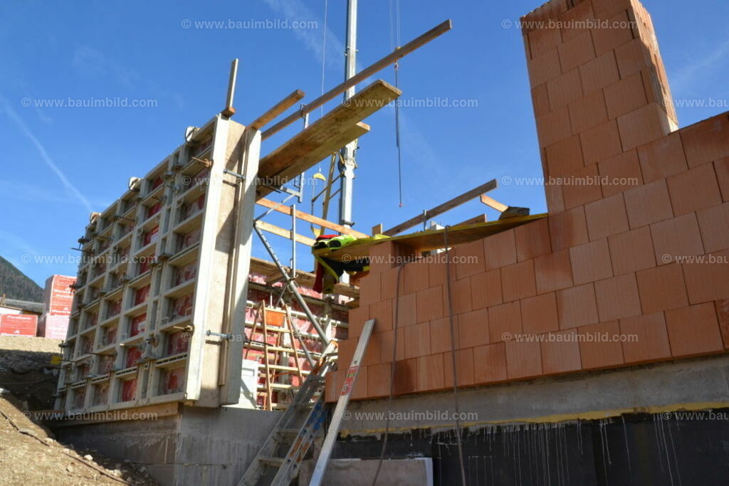 Ziegelmauerwerk und Betonwand | Erdgeschoß in Mischbauweise mit Ziegelmauerwerk und eingeschalten Betonwänden, Hintergrund blauer Himmel