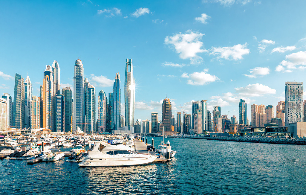 Beindruckende Skyline der Dubai Marina,Yachthafen und Uferpromenade | Das Bild zeigt die beeindruckende Skyline der Dubai Marina in den Vereinigten Arabischen Emiraten mit ihren markanten Wolkenkratzern und dem großen künstlichen Yachthafen.Die Marina liegt im Südwesten von Dubai und ist bekannt für ihre moderne Architektur, Luxusyachten und die lebhafte Uferpromenade (Dubai Marina Walk).Der etwa 3 Kilometer lange Yachthafen ist von zahlreichen hoch aufragenden Wohn- und Hoteltürmen umgeben, darunter einige der höchsten Wohnhäuser der Welt - Realisiert mit Pictrs.com