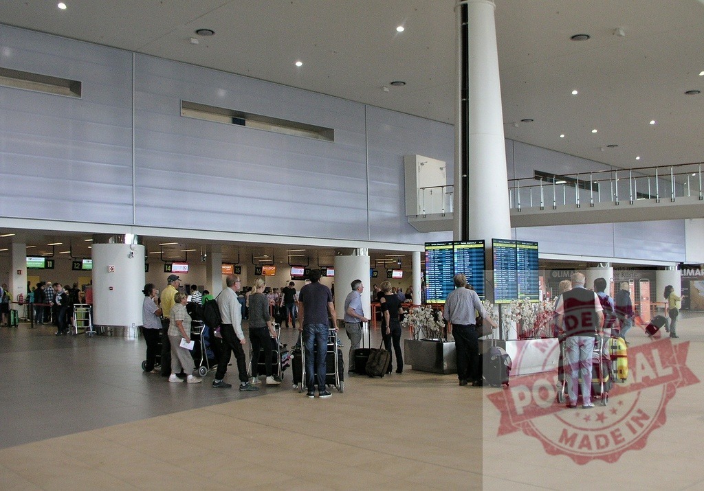 Travelers consulting departures board in airport terminal | Travelers are checking flight information on a departure board in a modern airport terminal - Realisiert mit Pictrs.com