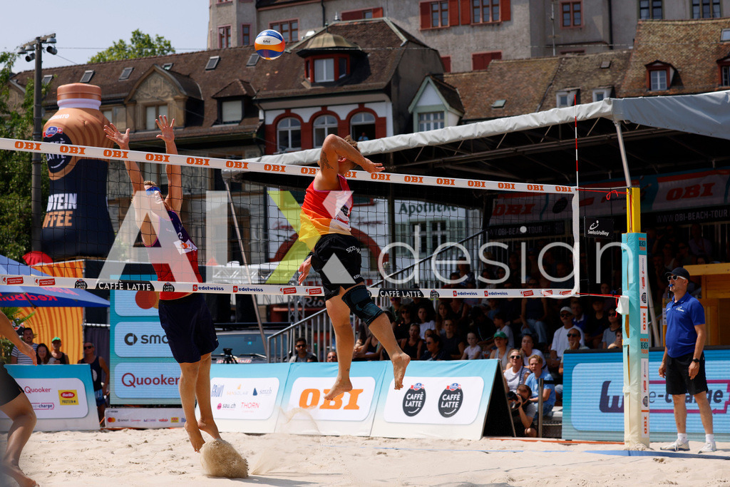 Obi BeachTour 2026 - Basel | BASEL, SWITZERLAND - JULY 19: MORITZ KINDL (AUT) attack / spike against MATHIS KÄLIN (SUI) block during the Obi BeachTour 2026 match between LEITNER / KINDL (AUT) and BREER / KÄLIN (SUI) at Barfüsserplatz on July 19, 2026 in Basel, Switzerland. - Realisiert mit Pictrs.com