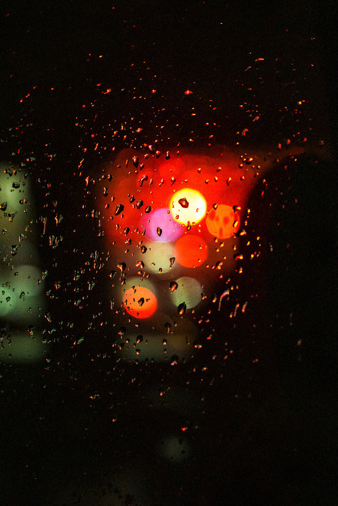 Lichter im Regen | Wassertropfen auf einer Fensterscheibe, dahinter verschwommene Lichter in warmen Farben. Dieses Bild zeigt eine typische Regenstimmung am Abend – modern, urban und stimmungsvoll. - Realisiert mit Pictrs.com
