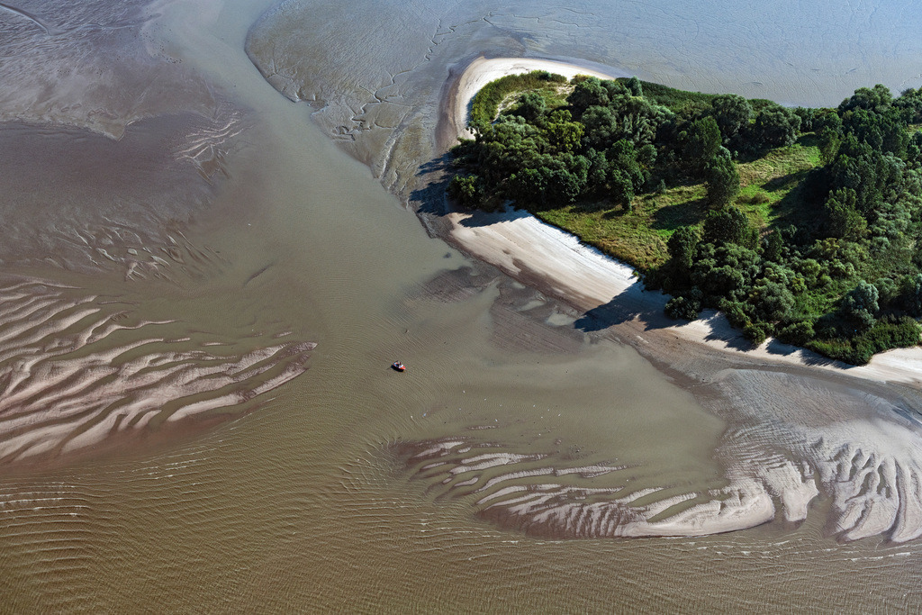 dr__0074491.jpg | HAHNöFERSAND 01.09.2021 Prielenbildung an den Uferbereichen mit Wattenlandschaft am Flußverlauf der Elbe in Hahnöfersand im Bundesland Niedersachsen, Deutschland. // Formation of tidal creeks on the bank areas with mud flats along the river of the River Elbe in Hahnoefersand in the state Lower Saxony, Germany. Foto: Daniel Reiter