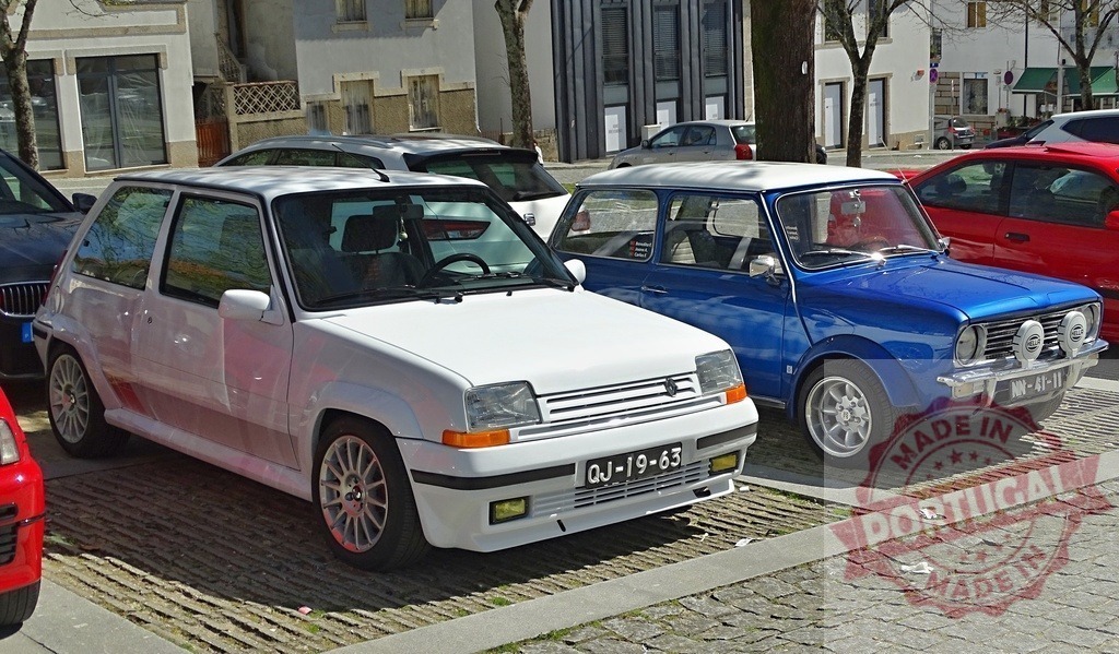 White Renault 5 Turbo and blue Mini Cooper parked on street | Classic sports cars parked side by side on a paved urban street on a sunny day - Realized with Pictrs.com