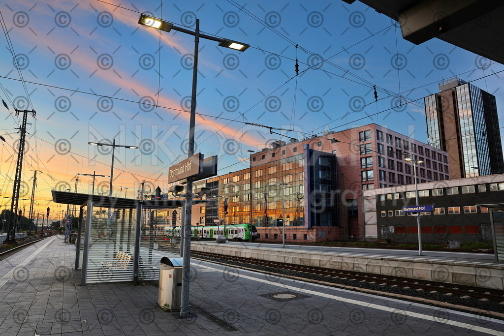 Morgenstimmung am Bahnsteig | Der Sonnenaufgang taucht die Gebäudefassaden am Bahnsteig des Dortmunder Hauptbahnhofes in ein goldenes Licht. Die Wolkenstreifen am Himmel glühen im Licht der aufgehenden Sonne.