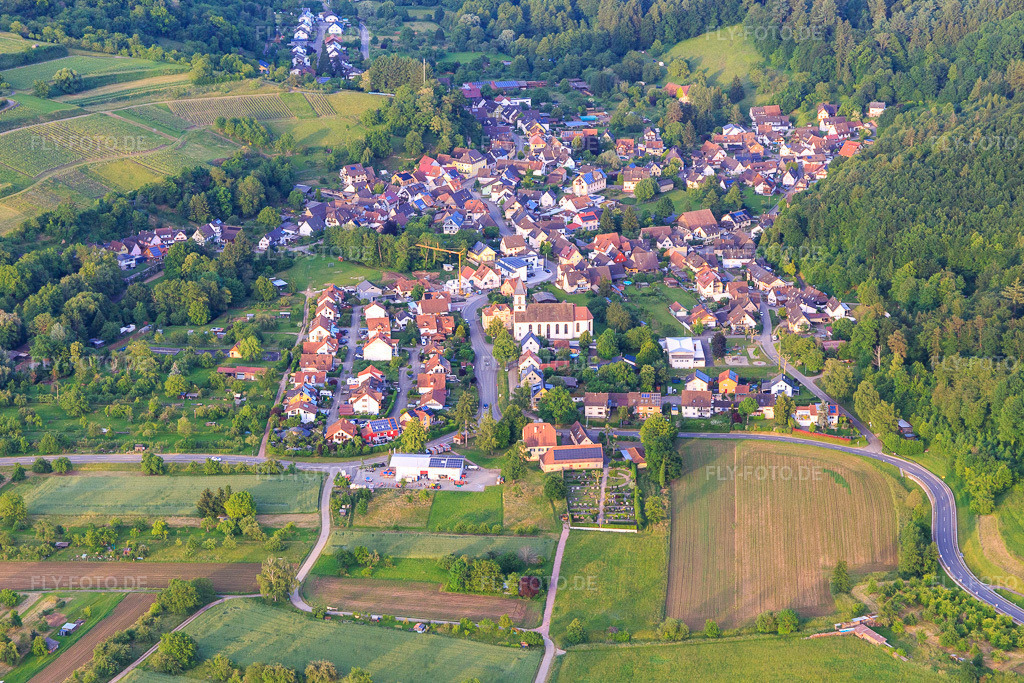 Luftbild: Winzerdorfansicht aus Westen mit Kirche St. Hilarius im Ortsteil Bleichheim in Herbolzheim im Bundesland Baden-Württemberg in Deutschland. Foto: IMG_147459.jpg vom 29.05.2025 durch Werner Riehm/FLY-FOTO.de