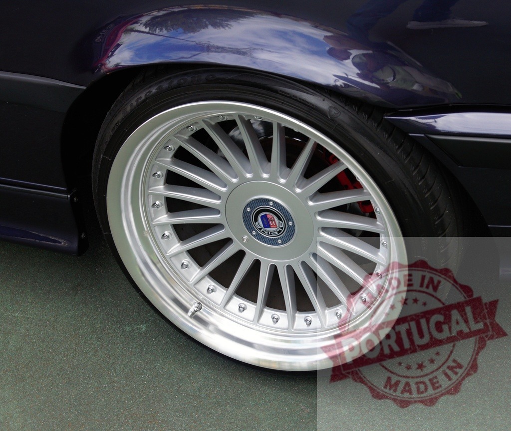 Alpina car wheel showing silver rim and tire | Alpina car wheel with silver alloy rim and black tire on a dark blue fender - Realized with Pictrs.com