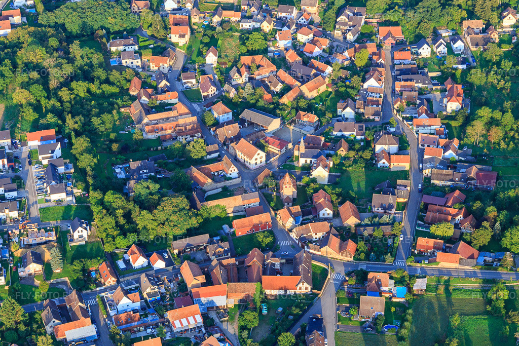 Vue aérienne: Centre du village avec église, école primaire et mairie à Wintzenheim-Kochersberg dans le département Bas Rhin, France – .Photo: IMG_138037.jpg prise le 19/08/2023 par Werner Riehm/FLY-FOTO.eu – Résolution de l'original: 5064 x 3376 px