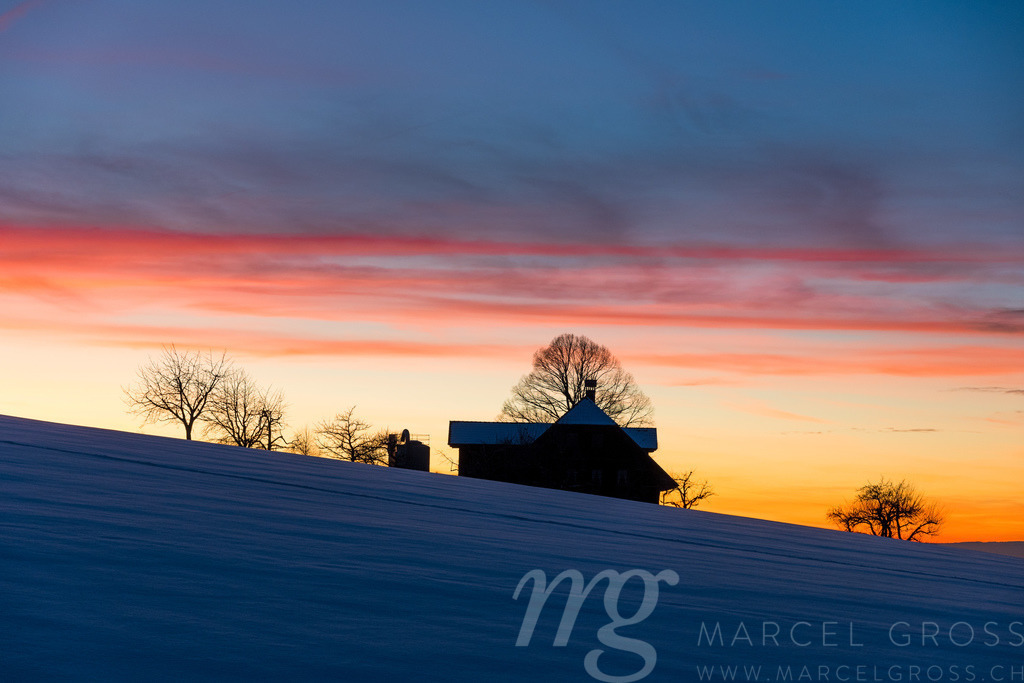 silhouette of a farm in Emmental at a winter sunset | Die ideale Geschenkidee für Naturliebhaber. Naturbilder von Marcel Gross Photography für ihr Zuhause in den verschiedensten Formaten und Materialien. - Realisiert mit Pictrs.com