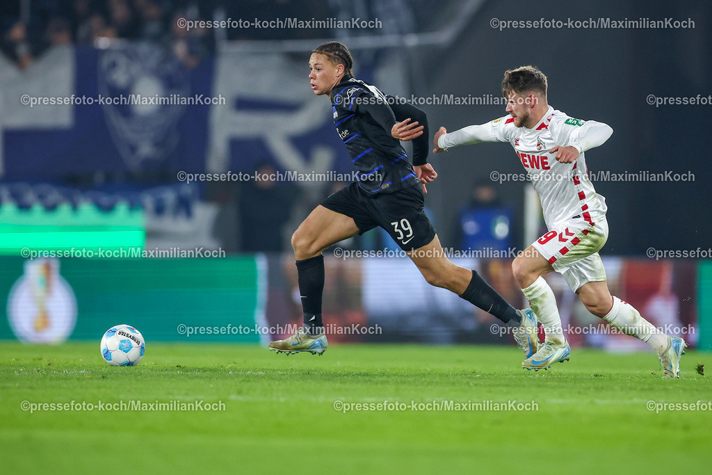 1FC04122401069 | 04.12.2024, Fußball, 1. FC Köln - Hertha BSC, Achtelfinale DFB-Pokal, RheinEnergieSTADION, Saison 2024 2025: Derry Scherhant (Hertha #39) im Zweikampf gegen Jan Thielmann (1.FC Köln #29)DFB regulations prohibit any use of photographs as image sequences and or quasi-video.