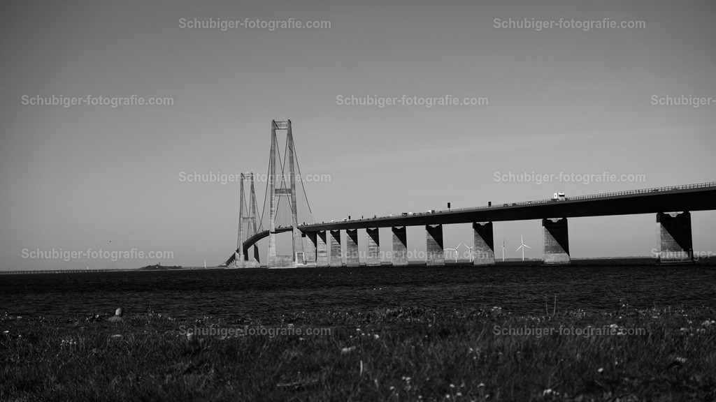 Storebaelt Brücke | Storebæltsforbindelsen ist die rund 18 km lange feste Verkehrsverbindung über den Großen Belt zwischen Slagelse auf der dänischen Insel Seeland und Nyborg auf Fünen. Über sie verlaufen die Eisenbahnverbindung København–Fredericia und die Europastraße 20. Wikipedia - Realisiert mit Pictrs.com