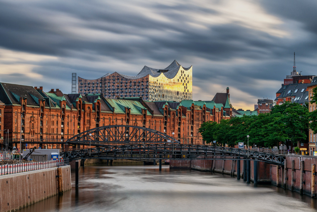 102307106 - Elbphilharmonie und Speicherstadt im Abendlicht | Blick über den Zollkanal auf die Häuser der Speicherstadt und die Elbphilharmonie.