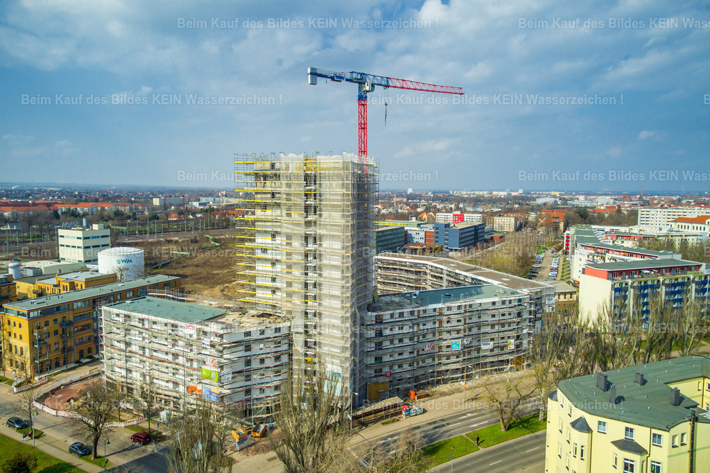 Luisenturm-0008 | Blick aus der Drohne auf den Luisenturm in Magdeburg während der Bauphase. Kran, Gerüste und die noch nicht fertiggestellte Fassade prägen das Bild und machen den aktuellen Bauzustand deutlich sichtbar.Die Aufnahme hält einen kurzen Abschnitt der Entstehung beziehungsweise Sanierung des markanten Bauwerks fest. Gerüste und Baukran werden später verschwunden sein – genau deshalb sind solche Aufnahmen als Baudokumentation besonders interessant.Die Drohnenperspektive zeigt dabei nicht nur den Luisenturm selbst, sondern auch seine Einbindung in das umliegende Stadtbild. So entsteht eine dokumentarische Aufnahme, die den Wandel eines Gebäudes über verschiedene Bauphasen nachvollziehbar macht. - Realisiert mit Pictrs.com