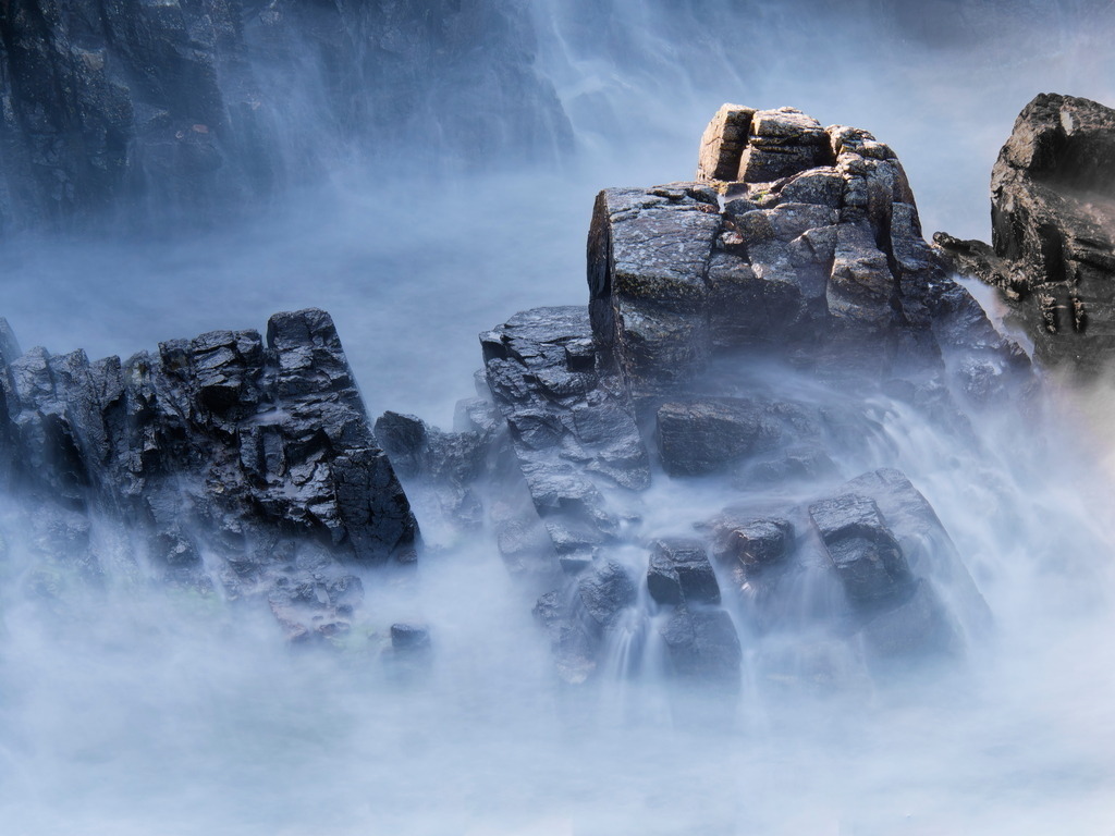 Tosende Gischt an felsiger Küste | Felsen an der Küste verschwinden fast in tosender Gischt - Realisiert mit Pictrs.com