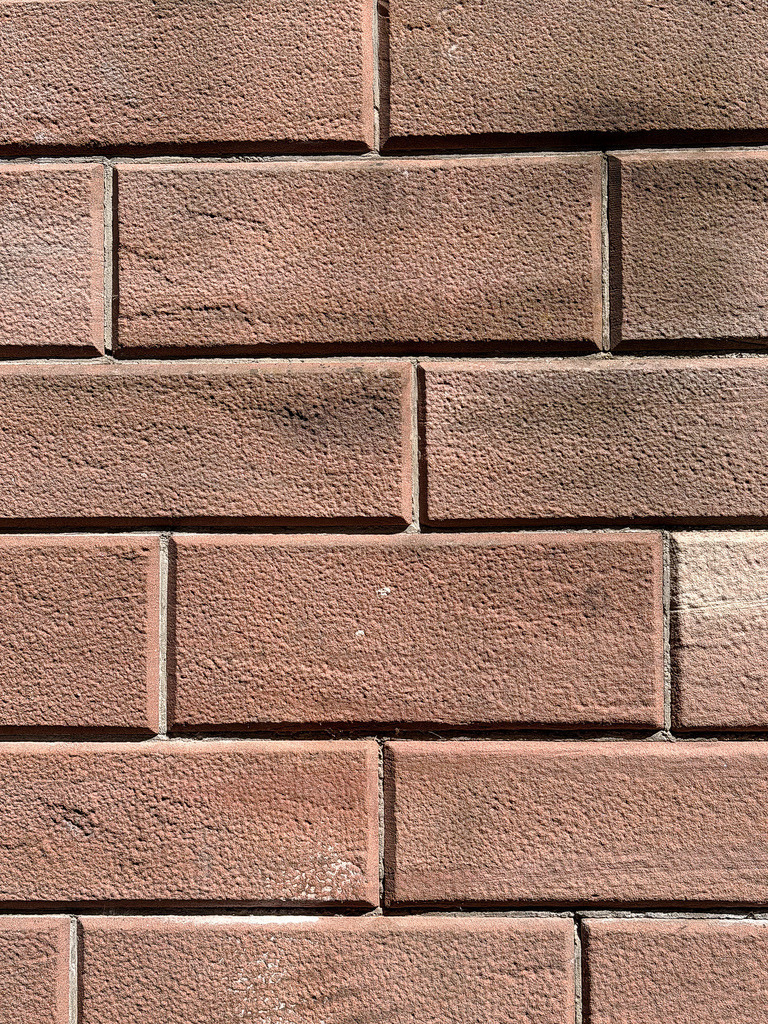 Red Brick Wall Texture | A high-resolution, close-up shot of a modern red brick wall. The detailed texture showcases the rough, porous surface of the stone blocks and clean grout lines. Perfect for architectural backgrounds, urban design concepts, and industrial style graphics. - Realisiert mit Pictrs.com