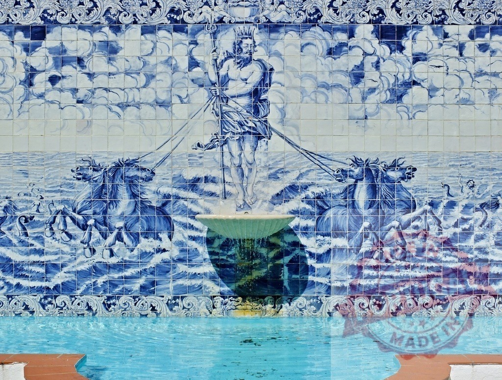 Poseidon azulejo mural with fountain and horses | Azulejo tile mural depicting Poseidon, horses, and ocean waves above a blue water fountain - Realized with Pictrs.com