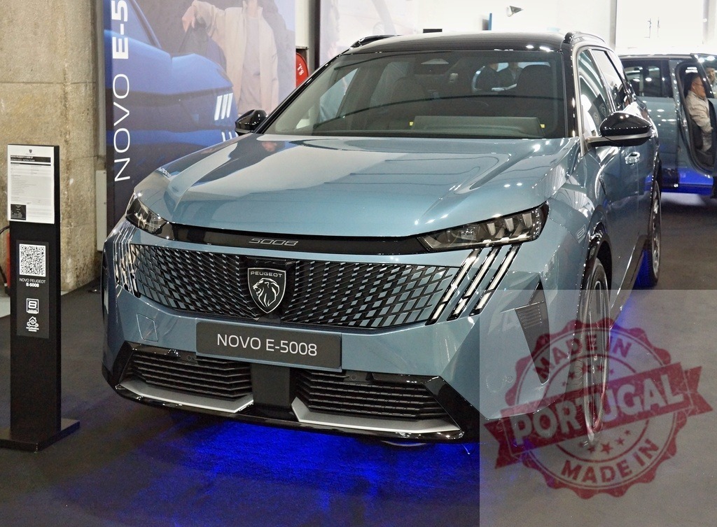 Peugeot E-5008 electric SUV front view at exhibition | Peugeot E-5008 electric SUV on display with blue ambient lighting at an automotive show - Realisiert mit Pictrs.com