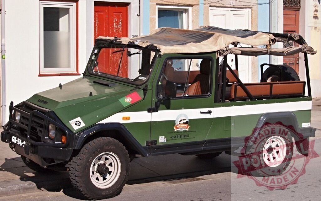 Green UMM safari jeep on a street in Portugal | Green UMM safari jeep parked on a street featuring a Portuguese flag - Realisiert mit Pictrs.com