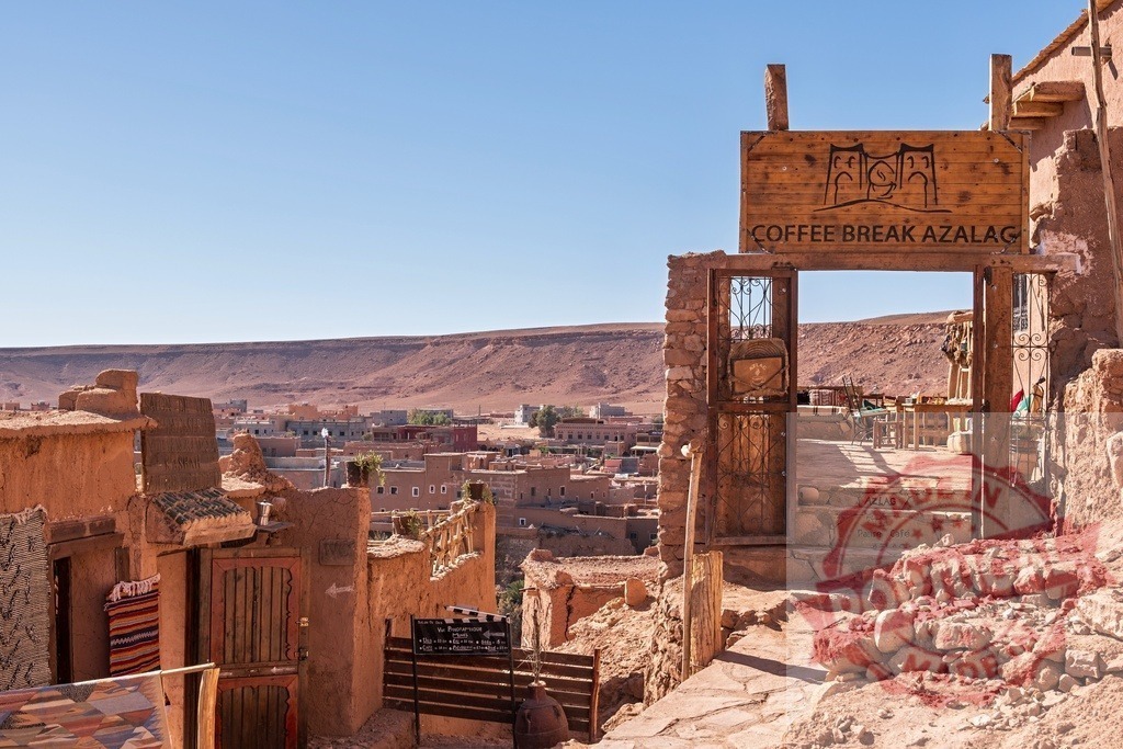 Coffee break sign overlooking Ait Benhaddou village in Morocco | Traditional Moroccan village of Ait Benhaddou with a coffee break sign and the desert landscape in the background - Realisiert mit Pictrs.com