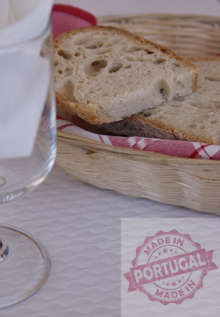 Rustic bread slices in wicker basket on table | Slices of fresh bread are filling a wicker basket with a checkered cloth during a meal - Realized with Pictrs.com