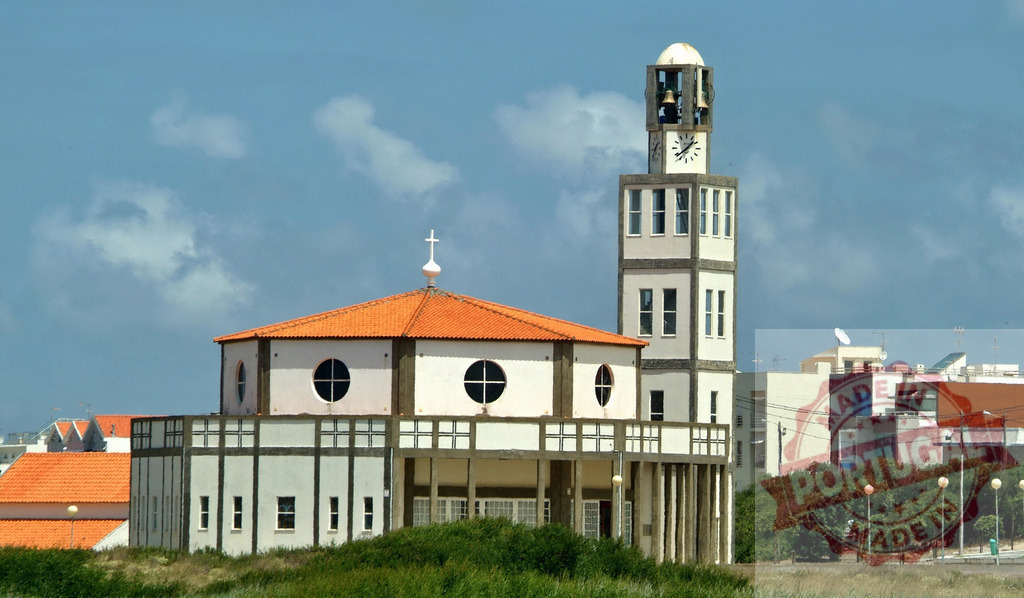 Modern church building with bell tower and cross. Centro Portugal | Church structure with an orange tiled roof standing under a blue sky, surrounded by green vegetation - Realisiert mit Pictrs.com