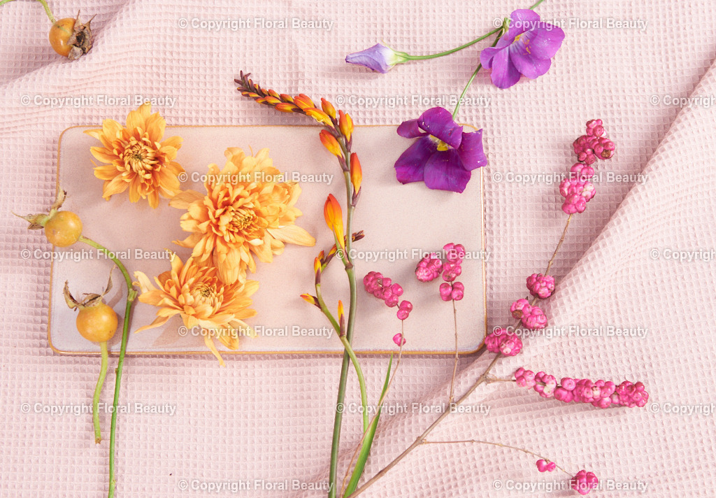 Blau-weiße Vasen mit Montbretien auf rosa | rosa Tablett mit gelegten Blüten auf rosa Untergrund - Realisiert mit Pictrs.com