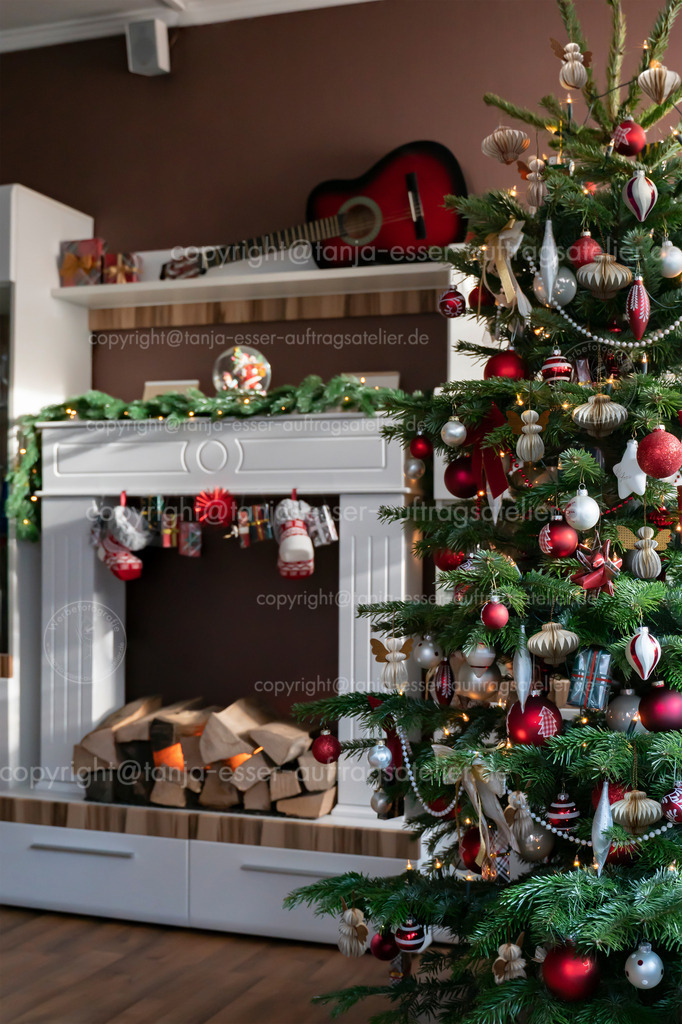 Weihnachtsbaum im Wohnzimmer Waben vertik  | Der Weihnachtsbaum im Wohnzimmer ist in Rot und Weiß und mit Weihnachtsbaum Ornamenten aus Wabenpapier geschmückt. Im Hintergrund ist ein elektrischer Kamin.