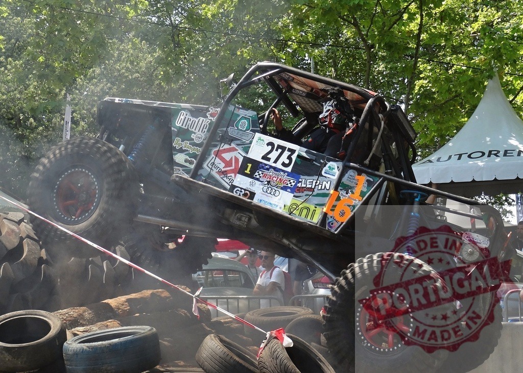 Powerful offroad vehicle climbing on tires during competition | Offroad vehicle climbing on tires during a competition showing its power and maneuverability - Realisiert mit Pictrs.com