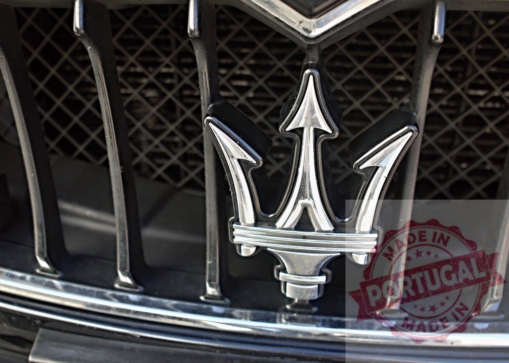 Maserati trident emblem adorning luxury car grille | Maserati trident logo on a black car grille representing Italian luxury and performance - Realized with Pictrs.com