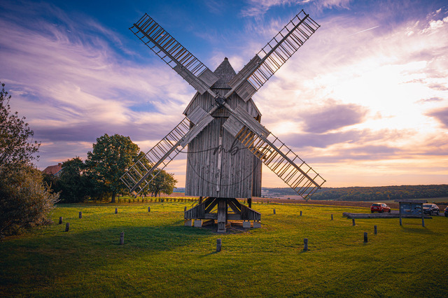 Bockwindmühle auf grüner Wiese, friedlicher Sonnenaufgangshimmel | Bockwindmühle auf grüner Wiese, friedlicher Sonnenaufgangshimmel, ländliches Idyll