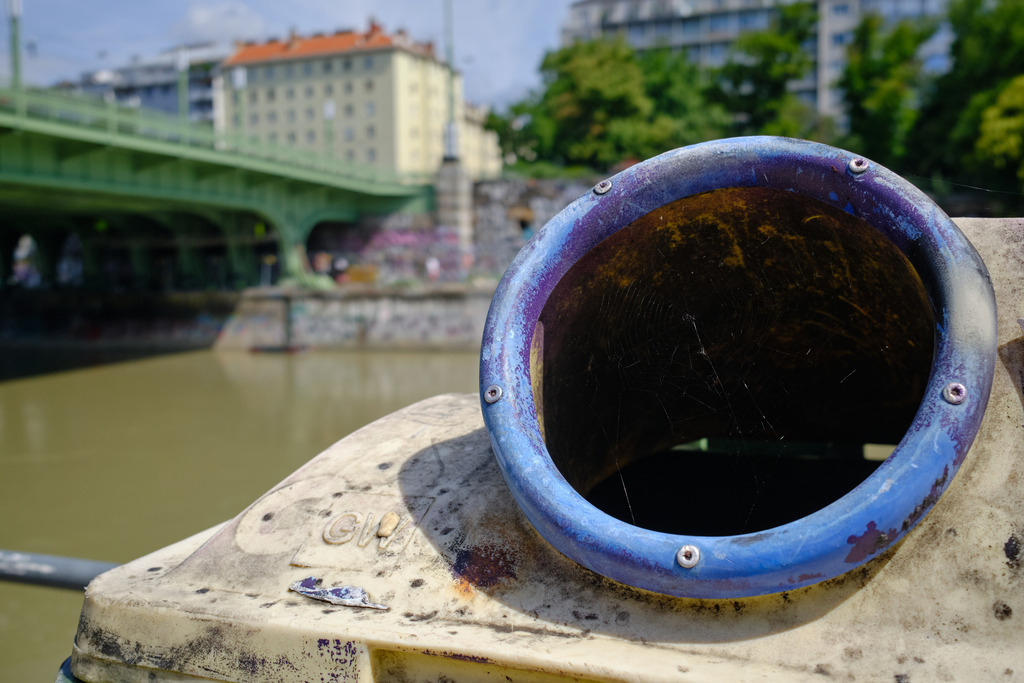 Flaschensammmel Container in Wien | Wien, Austria - August 03, 2025: Flaschensammmel Container in Wien, im Hintergrund eine Brücke und Wohnhäuser. - Realisiert mit Pictrs.com