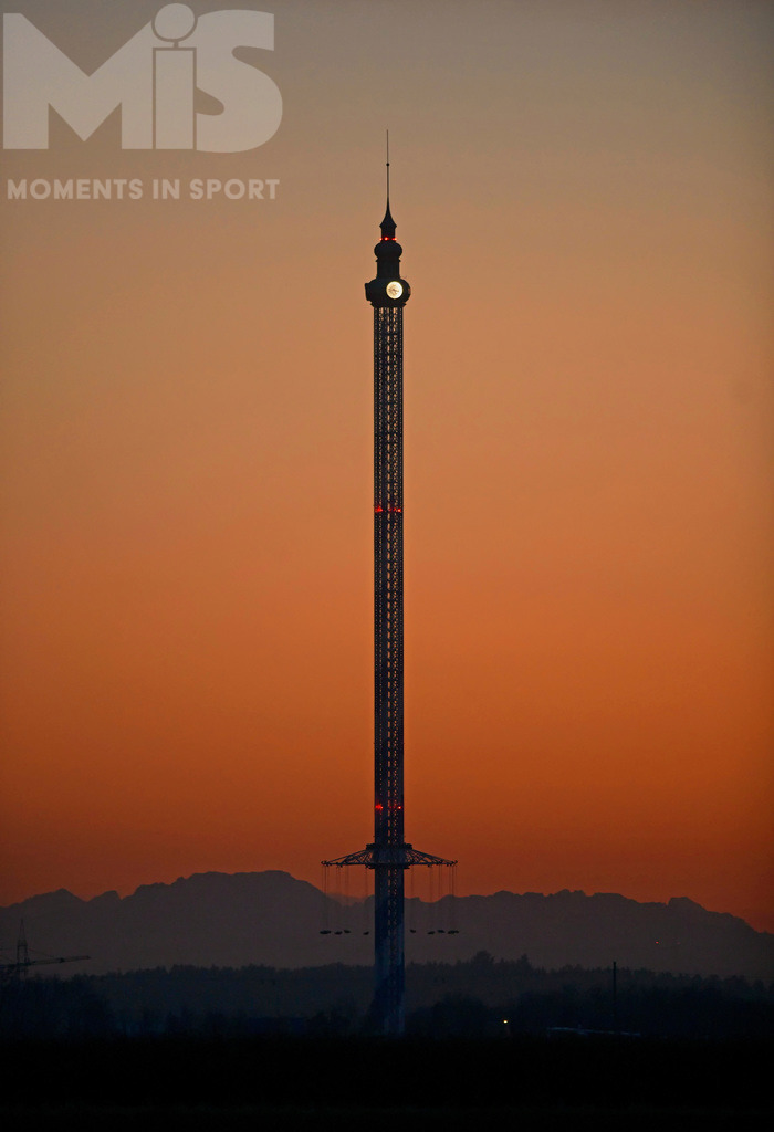 MIS_190920cm002.jpg | 10.11.2021, Der Allgäu-Flieger im Skylinepark Rammingen hat Pause, hinten das Abendrot und die Alpenkette, oben am Turm des großen Kettenkarusells leuchtet die Turmuhr und zeigt die Zeit an. - Realisiert mit Pictrs.com