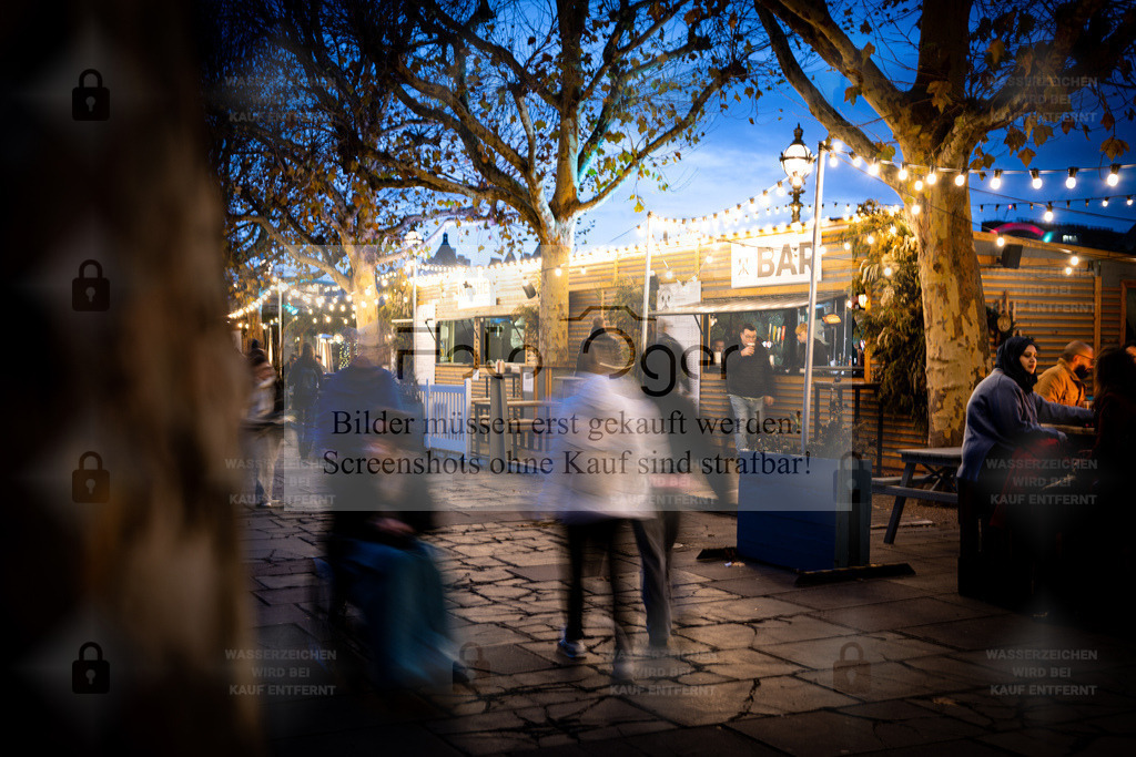 Evening Vibes by the Riverside | Zwischen Lichtketten, Gesprächen und dem sanften Rauschen der Themse entsteht ein Moment voller Leben.Dieses Bild fängt das urbane Treiben eines Londoner Abends ein – spontan, lebendig und warm zugleich. Ein Stück Großstadtgefühl zum Eintauchen. - Realisiert mit Pictrs.com