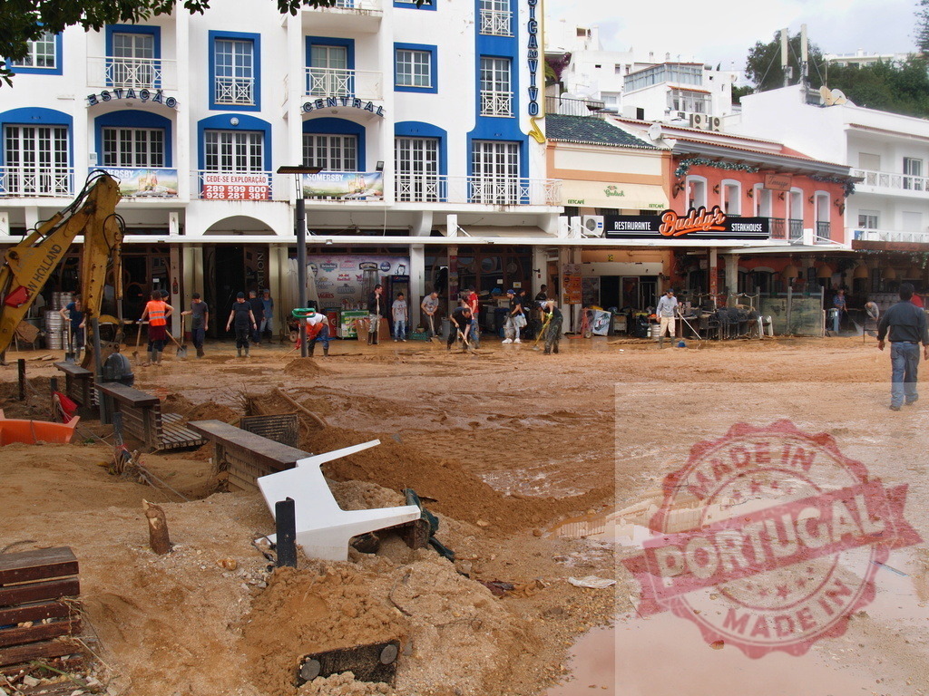 Residents cleaning muddy flood aftermath in Albufeira, Portugal | Albufeira Flood - discruction by weather problems Residents and an excavator cleaning mud from buildings and streets after a flood disaster - Realisiert mit Pictrs.com