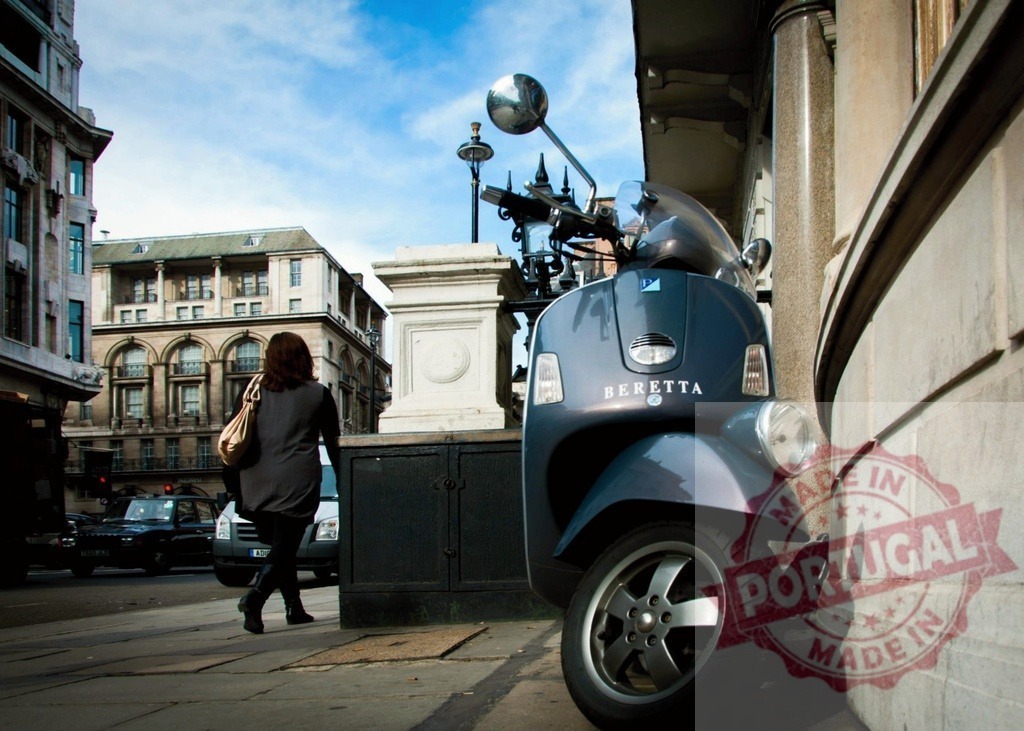 Woman walking away from a Beretta scooter parked in London | Blue Beretta scooter parked near a building in London with a woman walking on the sidewalk - Realisiert mit Pictrs.com