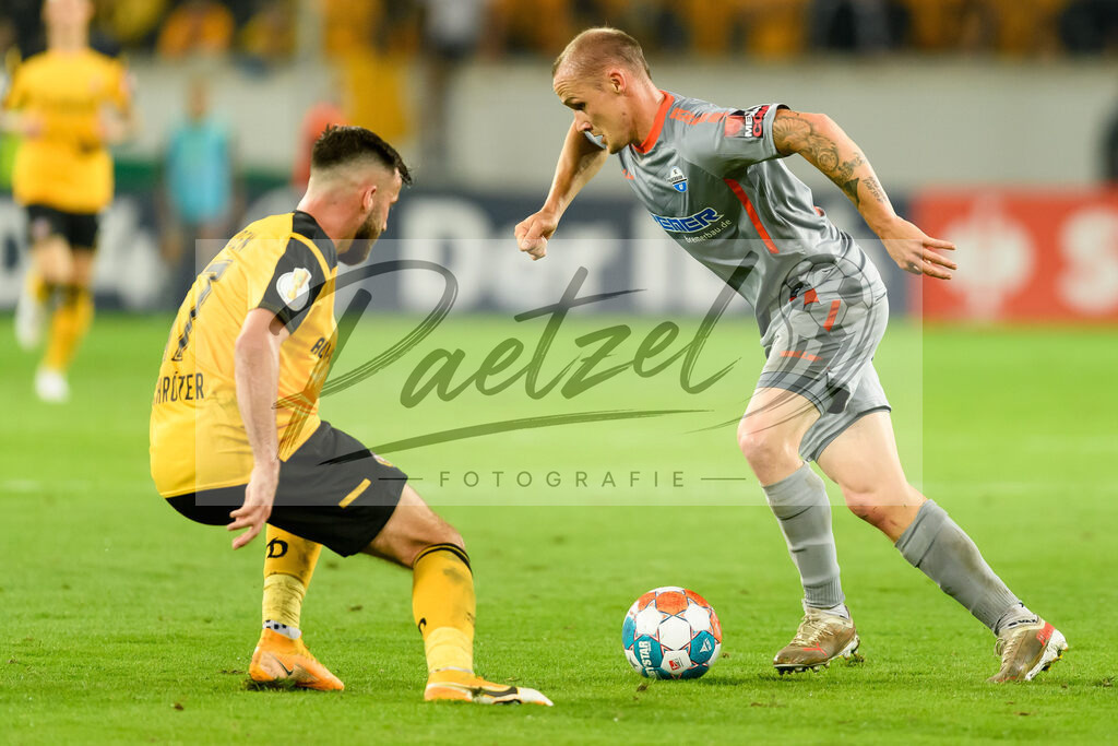 DREPAD20210806_032 | Fussball, Herren: Morris Schroeter (SG Dynamo Dresden) und Sven Michel (SC Paderborn 07) im Zweikampf beim Spiel der 1. Runde im DFB-Pokal zwischen SG Dynamo Dresden und SC Paderborn 07 im Rudolf-Harbig-Stadion am 06.08.2021 in Dresden, Deutschland.DFB / DFL REGULATIONS PROHIBIT ANY USE OF PHOTOGRAPHS AS IMAGE SEQUENCES AND/OR QUASI-VIDEO. - Realisiert mit Pictrs.com