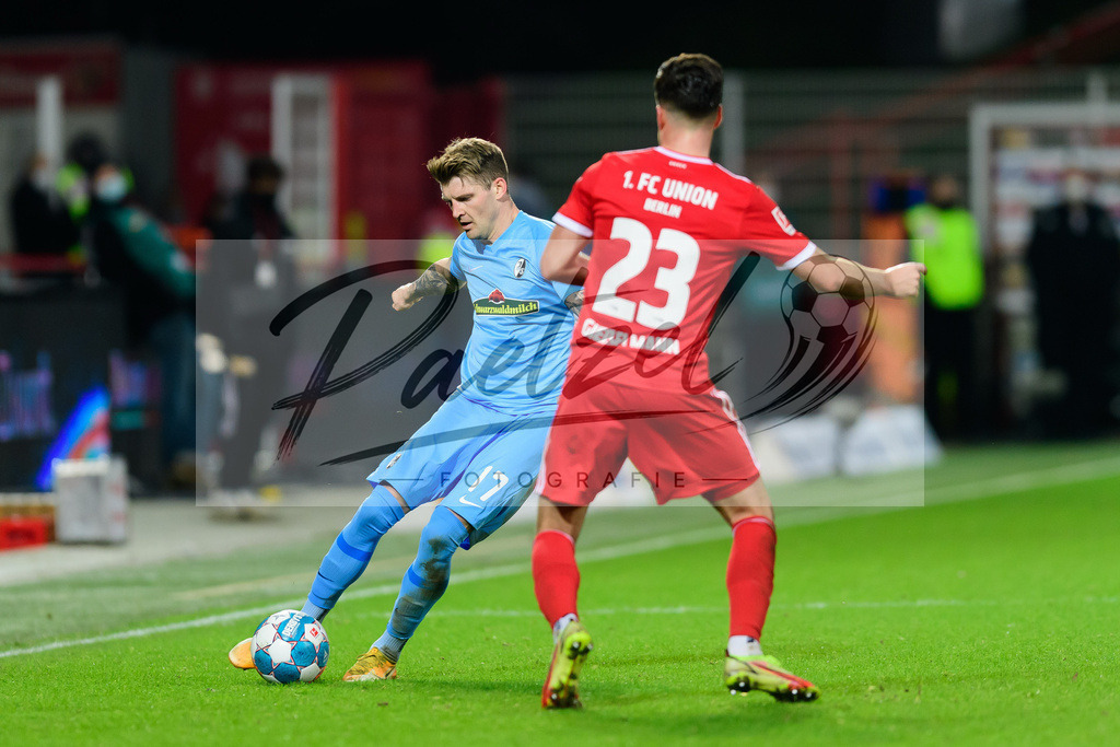 FCUFRE20211215_047 | Fussball, Herren: Lukas Kuebler (SC Freiburg) und Niko Giesselmann (1. FC Union Berlin) im Zweikampf bei dem Spiel der 1. Bundesliga zwischen 1. FC Union Berlin und SC Freiburg im Stadion An der Alten Foersterei am 15.12.2021 in Berlin, Deutschland.DFB / DFL REGULATIONS PROHIBIT ANY USE OF PHOTOGRAPHS AS IMAGE SEQUENCES AND/OR QUASI-VIDEO. - Realisiert mit Pictrs.com