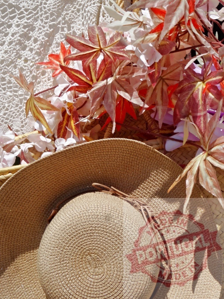 Straw hat with autumn leaves and white lace background | Straw hat resting near a basket filled with decorative autumn leaves and white flowers - Realisiert mit Pictrs.com