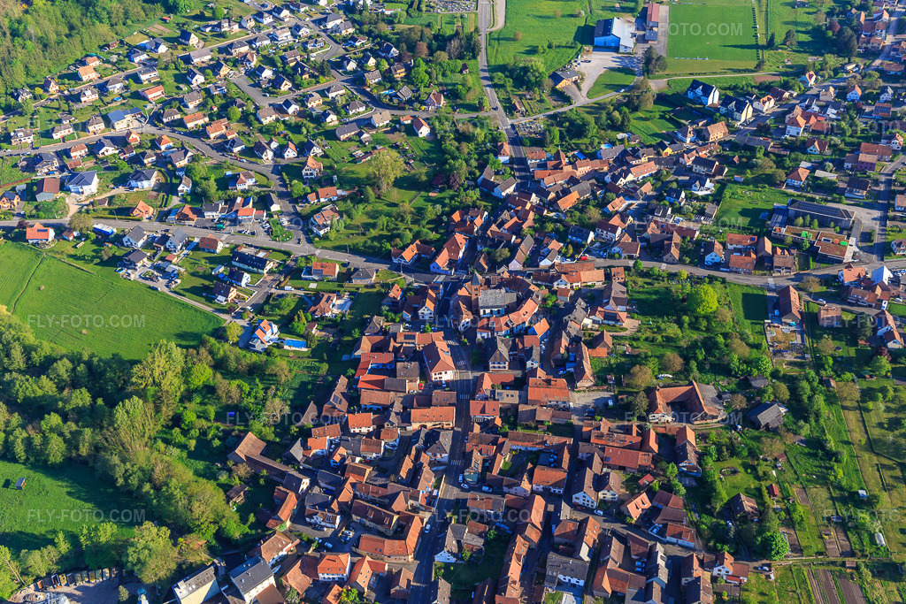 Aerial view: Town center from the south in Dossenheim-sur-Zinsel in the state Bas-Rhin, France. – Photo: IMG_146009.jpg taken on 05/01/2025 by Werner Riehm/FLY-FOTO.com – Resolution of the original: 5472 x 3648 px